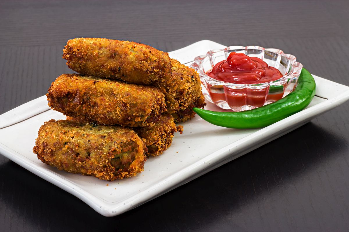 Spicy golden fried crisp cutlets served tomato sauce or ketchup on white plate, prepare for iftar Ramadan. Selective focus Chease Cutlet Recipe